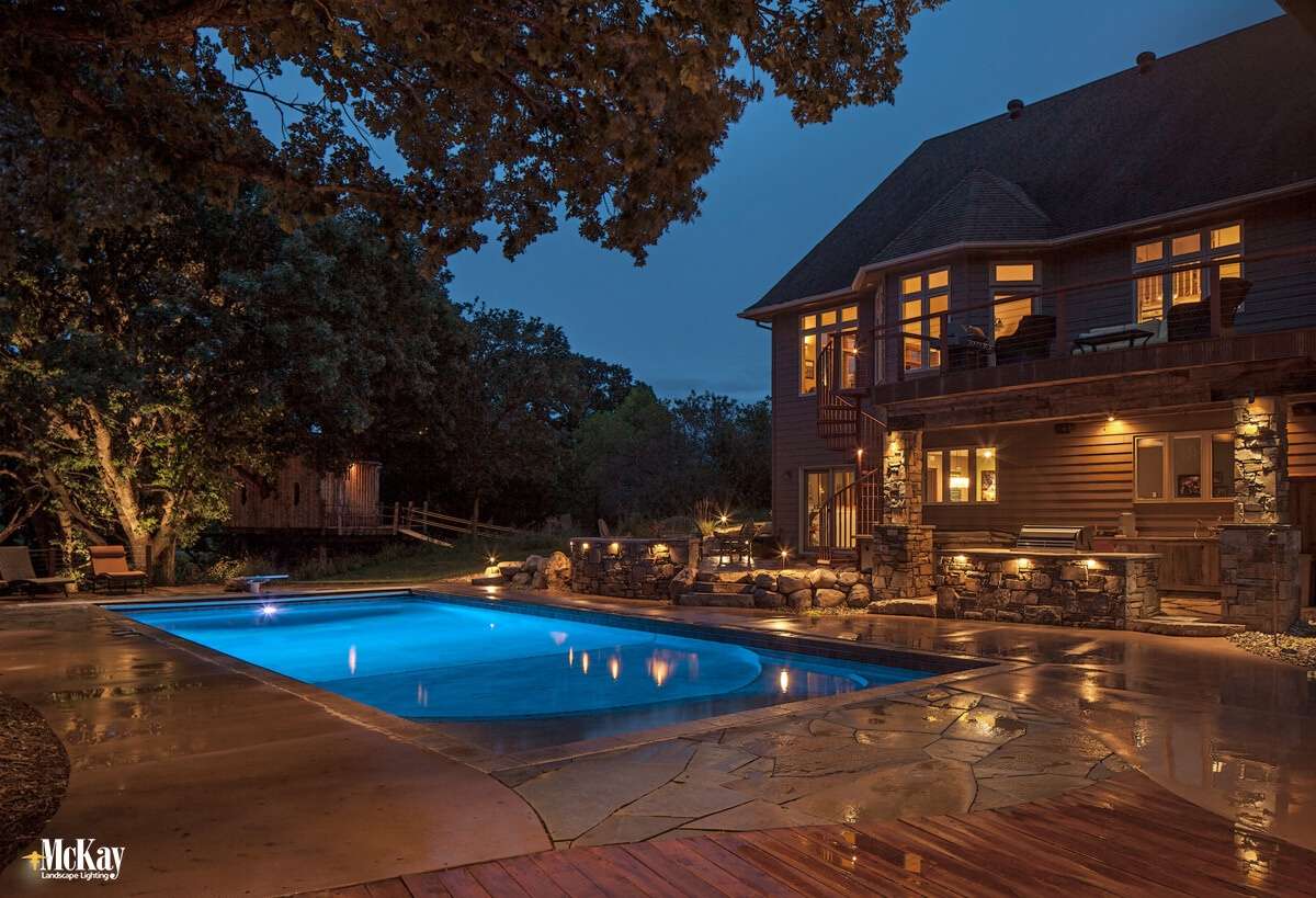 Using your pool at night can be hazardous, especially in areas like steps, walkways and pool edges. Adding outdoor lighting to the area around your pool provides a unique ambiance and increased safety. Click to learn more. | McKay Landscape Lighting Omaha Nebraska 